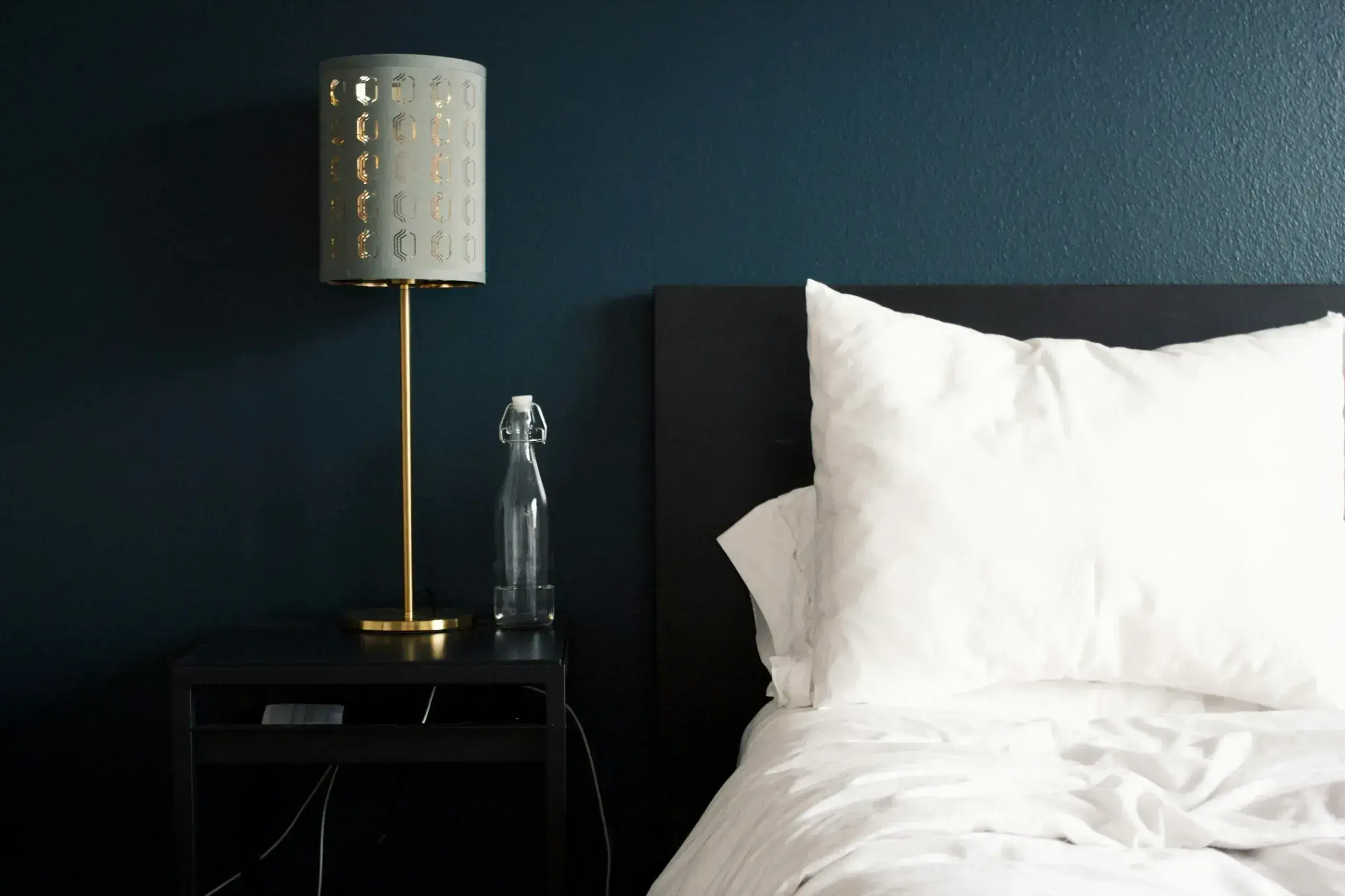Cozy bedroom with lamp and bedding.
